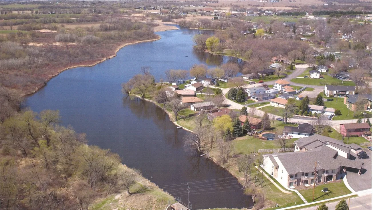 Aerial view of a river winding past homes and wetlands in Southeast Wisconsin