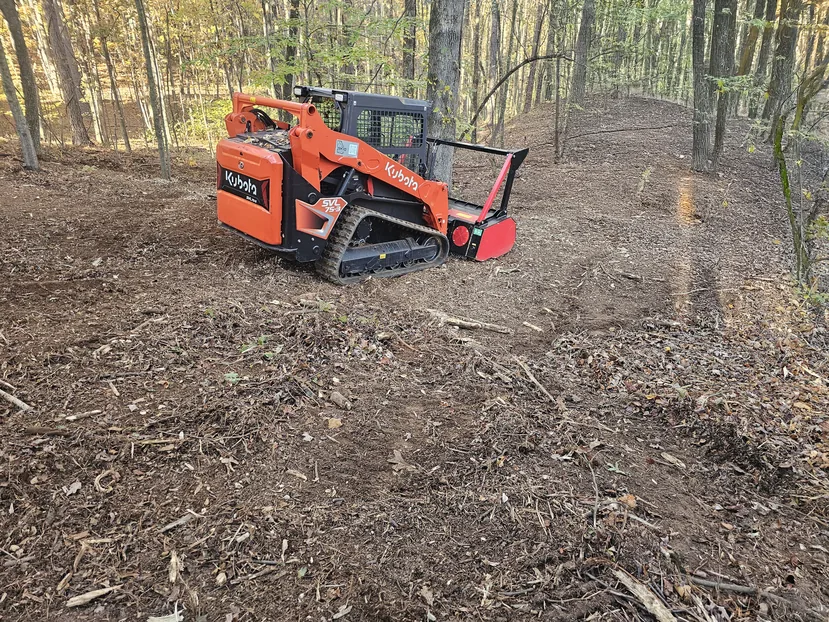 Forestry mulching on a wooded slope with a compact track loader and mulching head