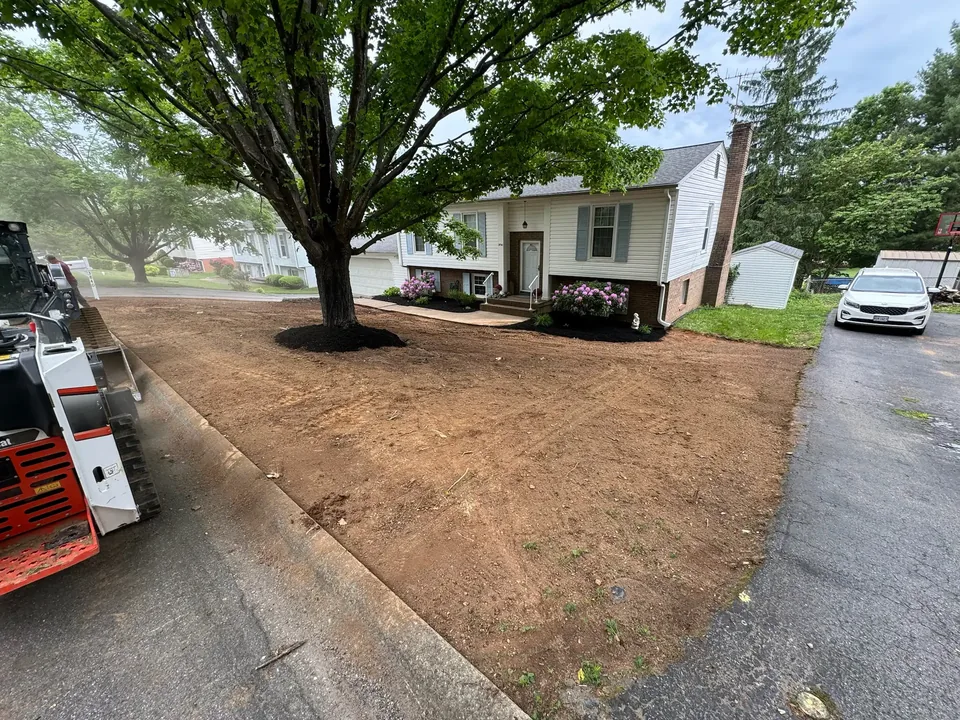 Front yard graded to bare soil beside the driveway after land grading