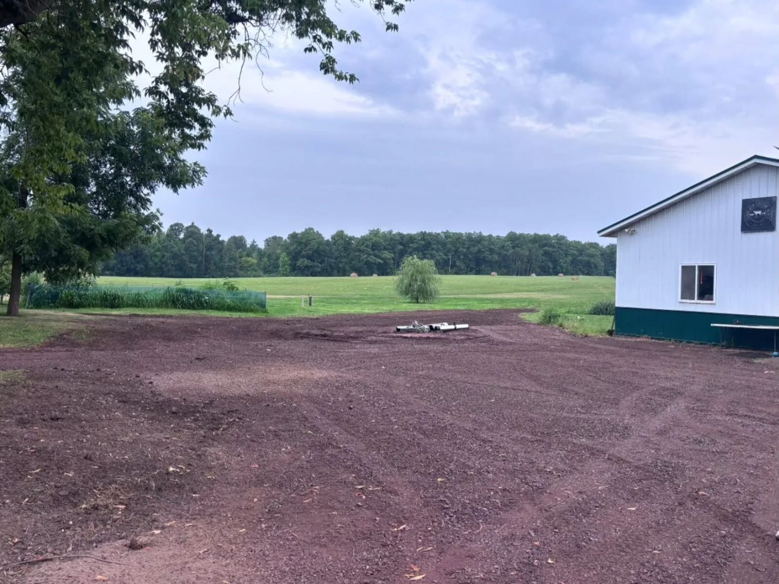 Graded dirt pad beside a pole building after land grading
