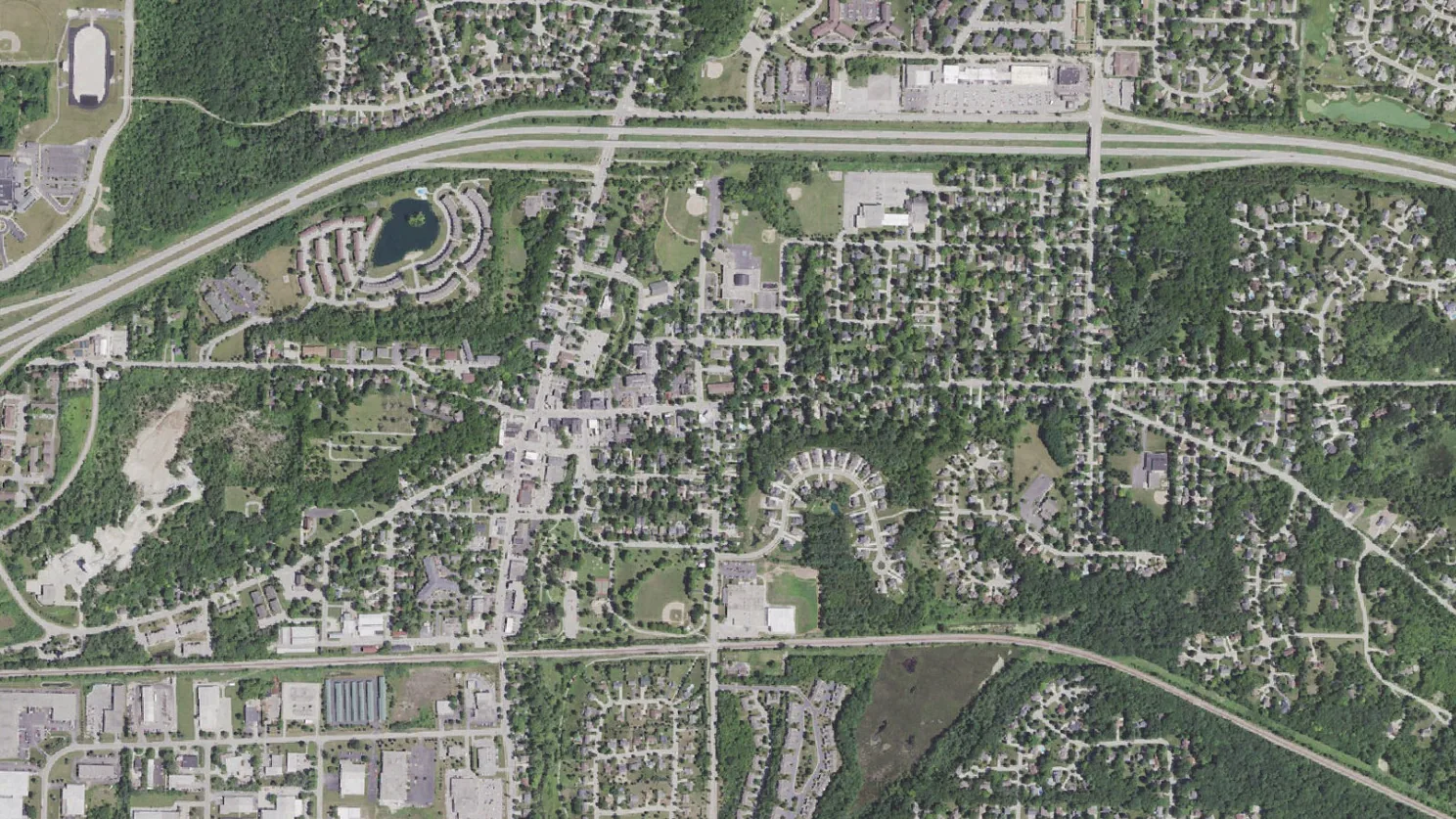 Aerial view of a village, woods and wetlands in Waukesha County, Wisconsin